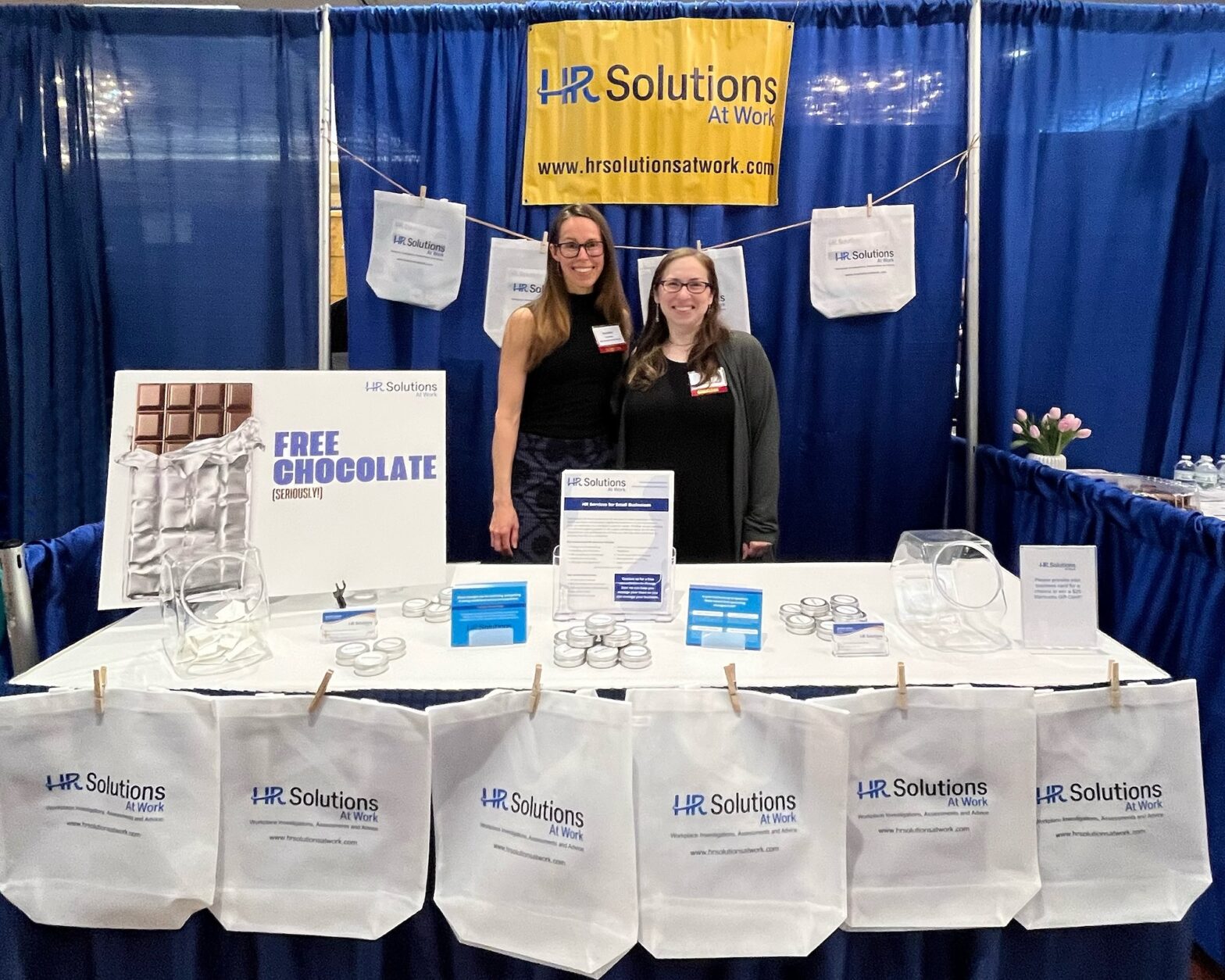 HR Solutions At Work staff members (from left to right) Natalie Costello and Jennifer London smiling at the company booth at the Expo event.